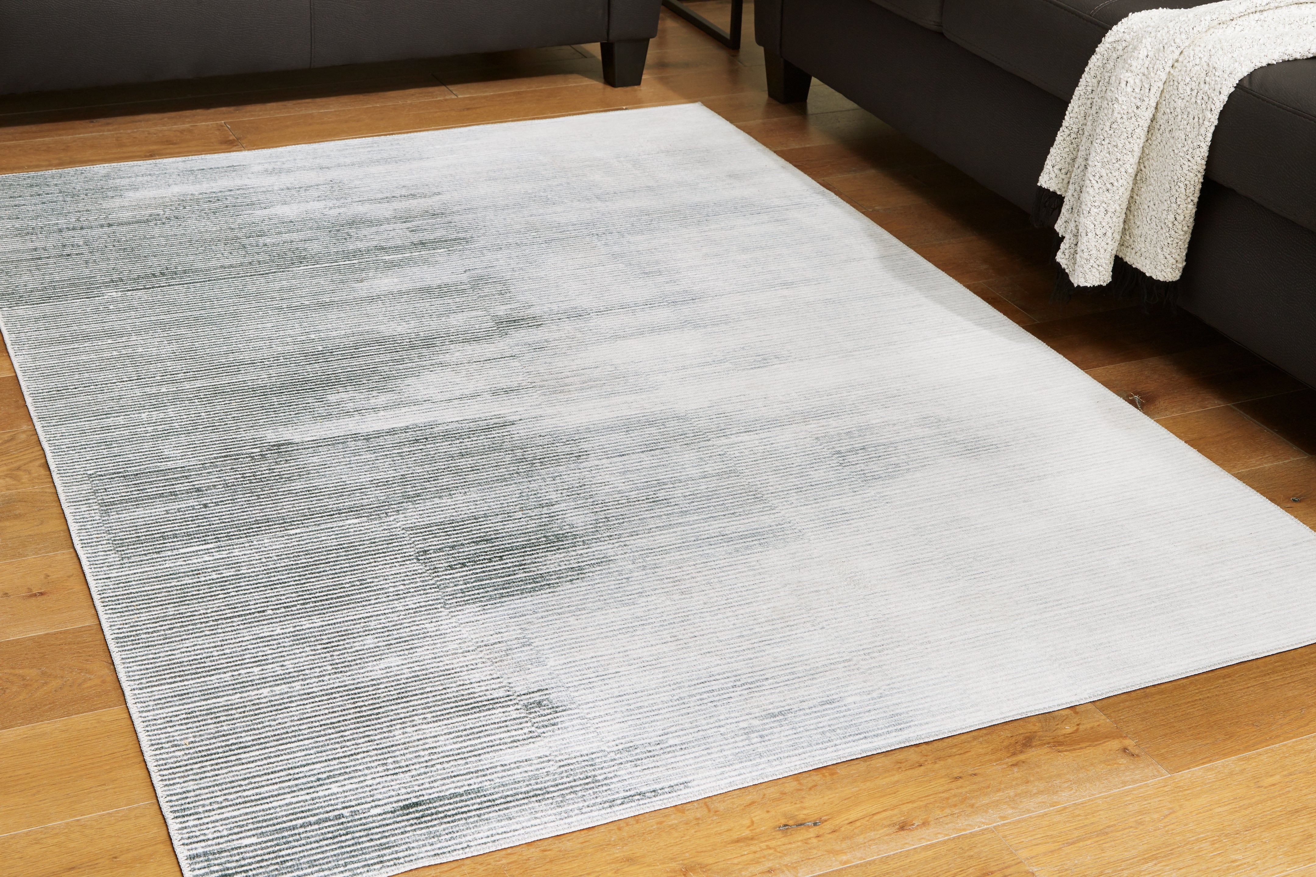 Warmstead Furniture - Ashley Furniture - Milset Rug - 8'1" x 10' Washable Rug / Black/White/Gray - R406251